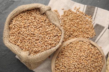 Kasede buğday taneleri ve siyah masada çuval bezi.