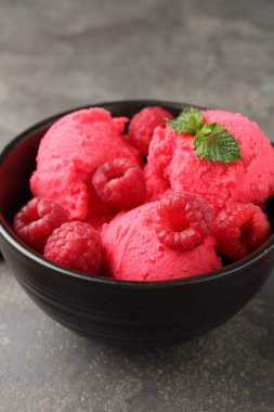 Lezzetli ahududu şerbeti, taze böğürtlenler ve gri desenli masada nane şekeri, yakın plan.