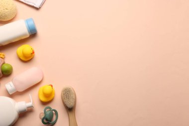 Bej arka planda bebek banyosu aksesuarları ve bakım ürünleri. Metin için boşluk