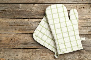 Fırın eldiveni ve tutacağı ahşap masada, üst tarafta. Metin için boşluk