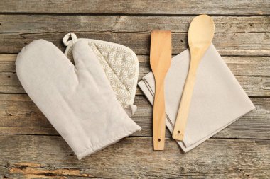 Fırın eldiveni ve diğer mutfak gereçleri ahşap masada, düz yatıyordu.