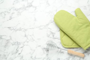 Fırın eldiveni, tutkal ve beyaz mermer masa üzerinde çırpı çırpı düz. Metin için boşluk