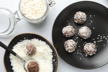 Beyaz masada fındıklı ve hindistan cevizli leziz çikolata şekerlemeleri yapmak.