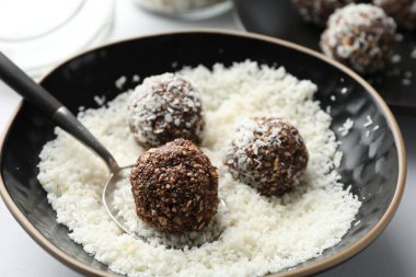 Beyaz masada fındıklı ve hindistan cevizli lezzetli çikolatalar yapmak, yakın plan.