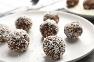 Gri masada fındıklı ve hindistan cevizli lezzetli çikolatalar, yakın plan.