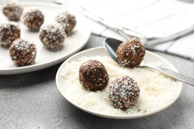 Gri masada hindistan cevizi gevreğiyle lezzetli çikolatalar yapmak, yakın plan.