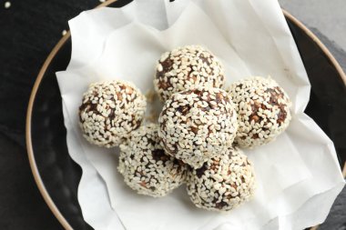 Fındıklı ve susamlı çikolatalı şekerler masanın üstünde, yukarıda.