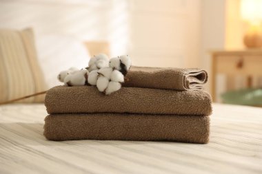 Evdeki çarşafların üzerinde temiz havlular ve pamuk çiçekleri yığını.