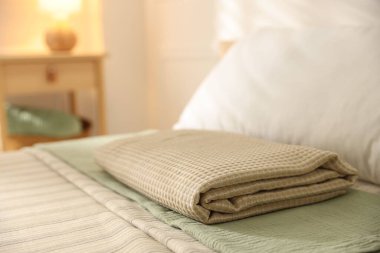 Evdeki çarşafların üzerine katlanmış havlu, yakın plan.