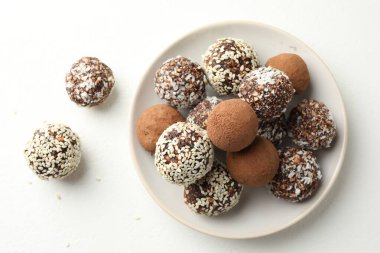 Beyaz masada kakao tozu, fındık ve susam tohumlu lezzetli çikolata şekerleri.