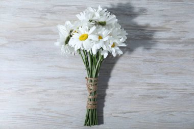 Gri ahşap masadaki güzel papatya çiçekleri.