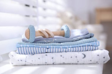 Temiz bebek kıyafetleri ve pencere pervazına aksesuar yığını.