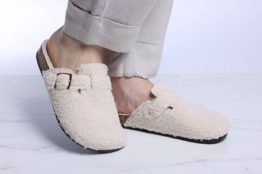 Beyaz mermer zeminde, yumuşak terlikli kadın, yakın plan.