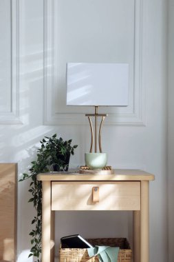 Yatağın içinde lamba ve diğer dekorlarla birlikte komodinin yanında.