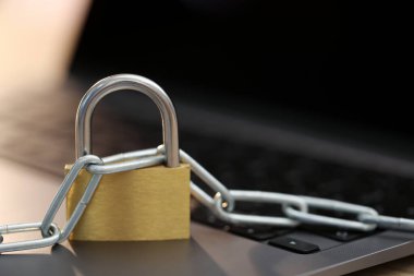 Siber güvenlik. Bilgisayarında zincir olan metal asma kilit, yakın plan. Metin için boşluk