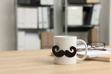 Babalar Günün kutlu olsun. Kağıt bıyıklı fincan, kitaplar ve gözlükler ahşap masada, metin için yer var.