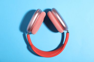 Açık mavi arka planda bir çift şık pembe kulaklık.