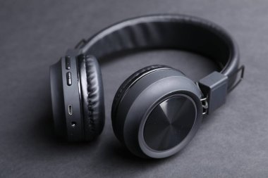 Siyah arka planda bir çift şık kulaklık, yakın plan.