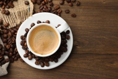 Aromatik kahve fincanda, fasulye de tahta masada, düz yerde. Metin için boşluk