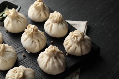 Siyah masada biberli pişmemiş khinkaliler (hamur tatlısı), yakın plan.