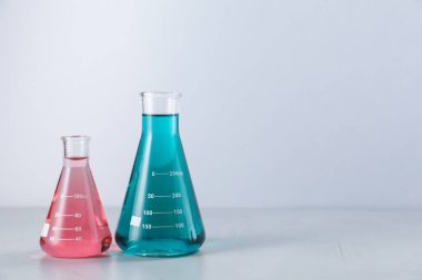 Işık arka planında renkli sıvılar olan mataralar. Metin için boşluk