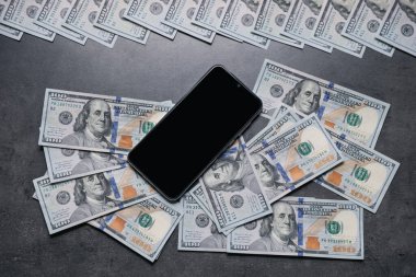 Akıllı telefon ve para gri masada, düz yatıyordu.