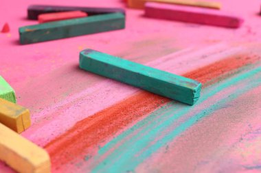 Pembe arka planda birçok renkli tebeşirli pastel, yakın plan.
