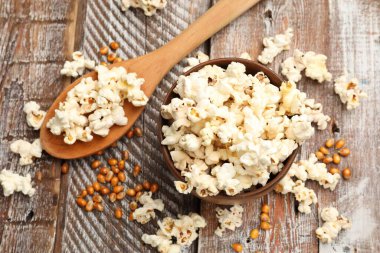 Tahta masada patlamış mısır ve mısır taneleri var.