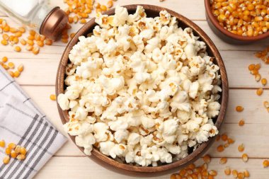 Lezzetli patlamış mısır ve mısır taneleri açık ahşap masada, düz yatıyordu.