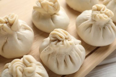 Beyaz ahşap masada pişmemiş khinkaliler (hamur tatlısı), yakın plan.