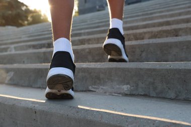 Genç çocuk merdivenlerden yukarı koşuyor, yakın plan.