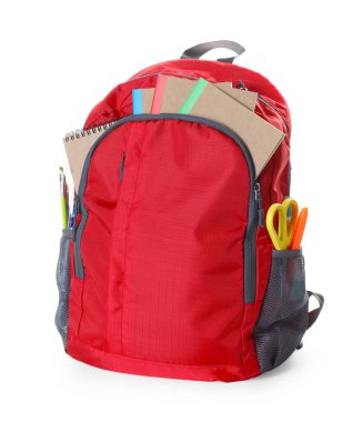 Beyaz üzerinde farklı kırtasiye malzemesi olan kırmızı sırt çantası