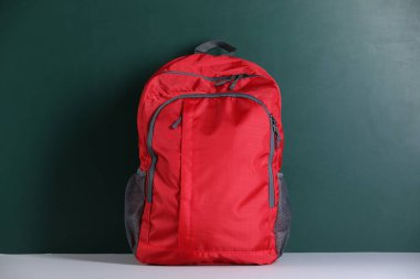 Masanın yanındaki kırmızı sırt çantası. Okula geri dön.