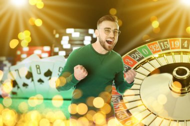 Mutlu kumarbaz zaferi kutluyor. Kumarhane fişleri, iskambil kağıtları ve ruletlerle çoklu pozlama.