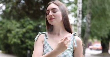 Gülümseyen kadın yüzüne termal su püskürtüyor.