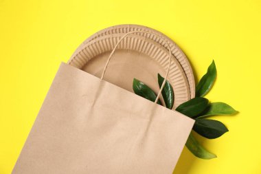 Farklı çevre dostu ambalaj ve sarı arka planda yapraklar, düz yatıyordu