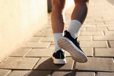 Spor giyimli atletik genç adam dışarı koşuyor, yakın plan. Metin için boşluk