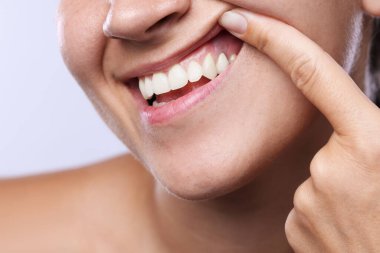 Dişlerini ve diş etlerini arka planda gösteren kadın, yakın plan.