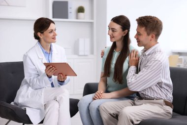 Tüp bebek (tüp bebek). Mutlu çiftin üreme kliniğinde doktorla randevusu var.