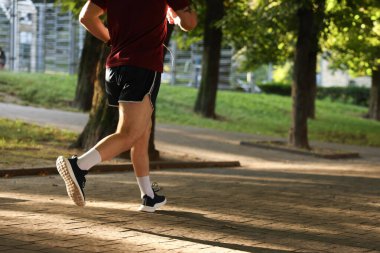 Spor giyimli atletik genç adam dışarı koşuyor, yakın plan. Metin için boşluk