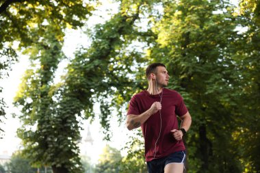 Spor giyimli atletik genç adam dışarıda koşuyor, mesaj için yer var.