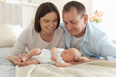 Anne ve baba yeni doğmuş bebekleriyle evde yatıyorlar.