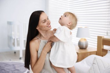 Annesi ve tatlı bebeği yataktaki odada.
