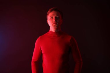 Siyah arka planda, neon ışıklı yakışıklı bir adam portresi.