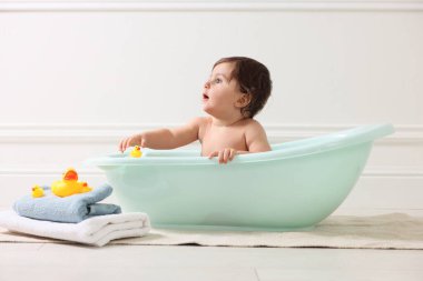 Evde küvette banyo yapan şirin bir bebek.