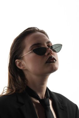 Siyah dudak kalemi olan güzel bir kadın beyaz arka planda ıslak güneş gözlüğü takıyor.