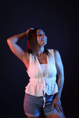 Siyah arka plana karşı neon ışıklı gülümseyen kadın.