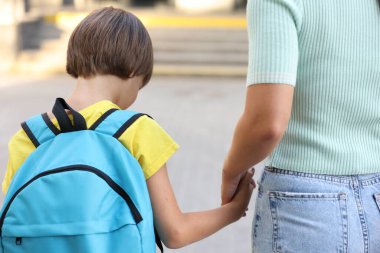 Anne oğlunu açık hava okuluna götürüyor.