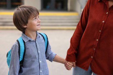Anne oğlunu açık hava okuluna götürüyor, yakın çekim.