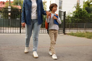 Anne oğlunu açık hava okuluna götürüyor, yakın çekim.